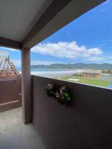 a balcony with two flower boxes and a large window at Residencial Mariano 5 in Florianópolis
