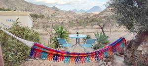 Casa Pura Vida في Relleu: أرجوحة مع طاولة وكراسي في الصحراء