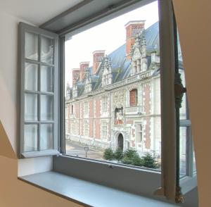 an open window with a view of a large building at Suite "États Généraux" face au château - LES SUITES DE BLOIS - 4 étoiles in Blois