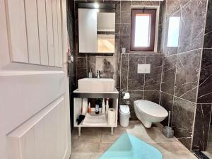ein Badezimmer mit Waschbecken, Toilette und Spiegel in der Unterkunft Derya'ca in Kaş