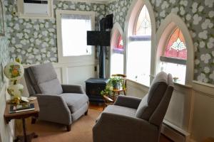 sala de estar con 2 sillas y 2 ventanas en Black Friar Inn and Pub en Bar Harbor