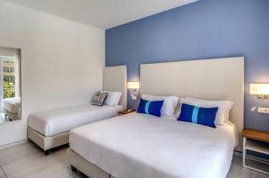 um quarto de hotel com duas camas com paredes azuis em Sweet Home em Concordia Sagittaria