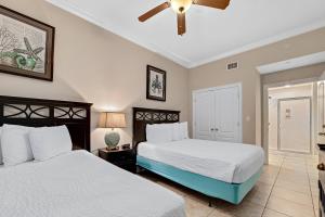 a bedroom with two beds and a ceiling fan at Phoenix Gulf Shores 2102 in Gulf Shores