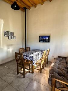 Un comedor con una mesa y sillas y una cama. en Cabañas Entre Lagos San Rafael, en San Rafael