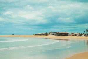 a view of a beach with houses and the ocean at Pousada Chalé Mar Rio in Galinhos