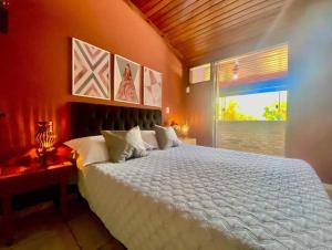 a bedroom with a white bed and a window at Aconchego de geriba in Búzios