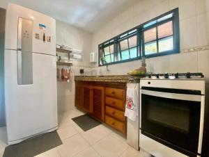 uma cozinha com um frigorífico branco e um fogão em Aconchego de geriba em Búzios