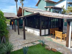 ein Haus mit einer Terrasse mit einem Tisch und Stühlen in der Unterkunft Aconchego de geriba in Búzios