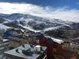 una vista aérea de una ciudad con montañas cubiertas de nieve en Sierra Nevada Serraneu Vistas, en Sierra Nevada