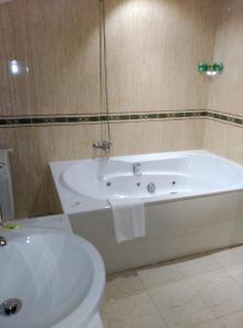 a bathroom with a white tub and a toilet at Hotel San Cibrao in San Ciprián de Viñas