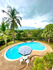 メルガルにあるEspectacular CASA FINCA con piscina, WiFi Y AAのスイミングプール(パラソル、椅子2脚、テーブル、パラソル付)