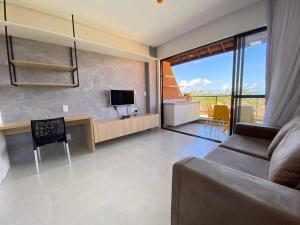 een woonkamer met een bank en een televisie bij Flat Eco Resort Praia Carneiros, Tamandaré. Porto dos corais 202 in Tamandaré