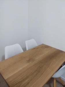 a wooden table with four white chairs around it at Ferienwohnung in Niedraula in Niederaula