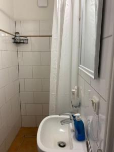 een witte badkamer met een wastafel en een douche bij Schöne Ferienwohnung/Pendlerwohnung in Uelzen
