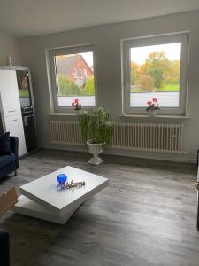 a living room with a table and two windows at Schöne Ferienwohnung/Pendlerwohnung in Uelzen