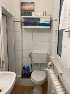 Schöne Ferienwohnung/Pendlerwohnung في أويلتسن: حمام ابيض مع مرحاض ومغسلة