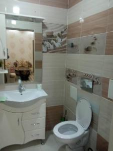 y baño con aseo y lavamanos. en Apartment in the 7th Microdistrict en Bishkek