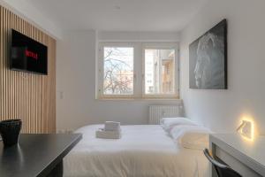 um quarto branco com uma cama, uma secretária e uma janela em Lionne-Stade du Lou em Lyon