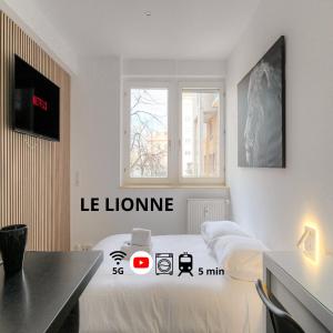um quarto branco com duas camas e uma mesa em Lionne-Stade du Lou em Lyon