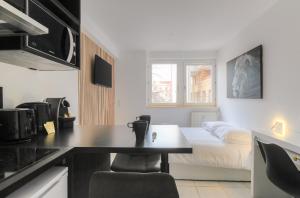 a kitchen with a table and a bed in a room at Lionne-Stade du Lou in Lyon