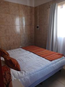uma pequena cama num quarto com uma janela em MARDIFIORE 4 em General Juan Madariaga