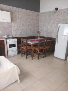uma cozinha com uma mesa e um frigorífico branco em MARDIFIORE 4 em General Juan Madariaga