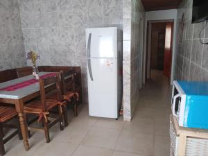 uma cozinha com um frigorífico e uma mesa com cadeiras em MARDIFIORE 4 em General Juan Madariaga