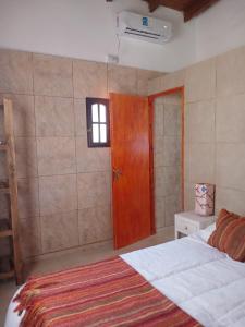um quarto com uma cama e uma porta de madeira em MARDIFIORE 4 em General Juan Madariaga