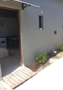 uma porta aberta de uma casa branca com flores em MARDIFIORE 4 em General Juan Madariaga