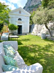 un gruppo di divani seduti sull'erba di fronte a un edificio di Agriturismo Sant'Alfonso a Furore