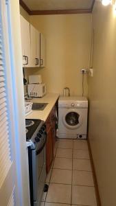 a small kitchen with a washing machine and a washer at Ya mon inn in Negril