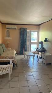 a bedroom with a bed and a table and a desk at Ya mon inn in Negril