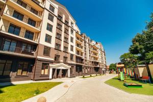 um grande edifício de apartamentos com um parque infantil em frente em Central Apartments Chisinau em Chisinau