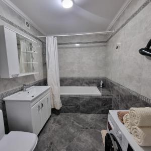 uma casa de banho com uma banheira, um WC e um lavatório. em Central Apartments Chisinau em Chisinau