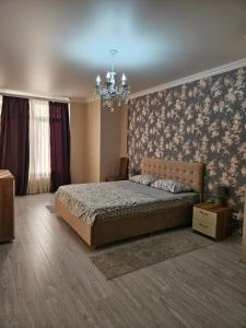 1 dormitorio con cama y lámpara de araña en Central Apartments Chisinau en Chisináu