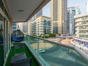 a balcony with chairs and a swing and a city at In the Heart of the Marina, by the beach! in Dubai