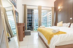 a bedroom with a large bed and a large window at In the Heart of the Marina, by the beach! in Dubai