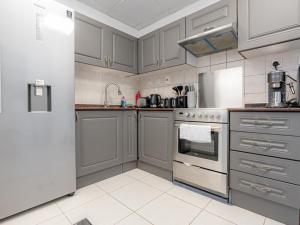 a kitchen with gray cabinets and a refrigerator at In the Heart of the Marina, by the beach! in Dubai