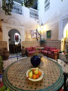 Cette chambre comprend une table avec un bol de fruits. dans l'établissement RIAD Redous, à Marrakech