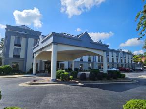 un grand bâtiment bleu avec un parking dans l'établissement Wingate by Wyndham Greensboro-Coliseum, à Greensboro