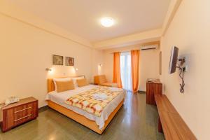ein Hotelzimmer mit Bett und Fernseher in der Unterkunft Hotel Novi in Herceg-Novi + 18 Fotos