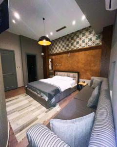 um quarto com uma cama e um sofá em Guest House People em Korçë