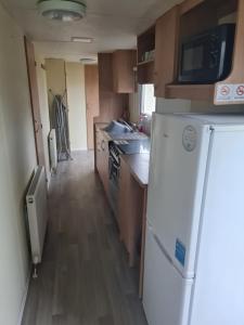 a small kitchen with a refrigerator and a sink at 31 Beachlands in Cowes