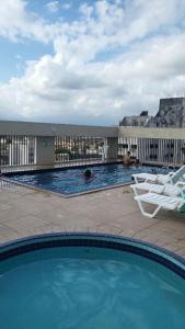 a large swimming pool with a chair and a chair at Flat Palladium São Vicente in São Vicente