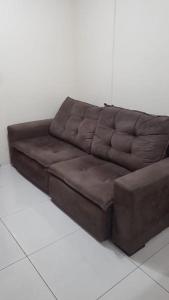 a brown leather couch sitting in a room at Flat Palladium São Vicente in São Vicente