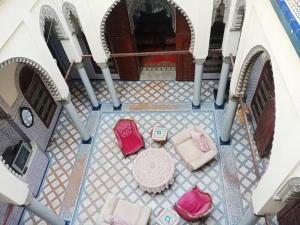 an overhead view of a patio with pink chairs and a table at ryad lhaja in Rabat