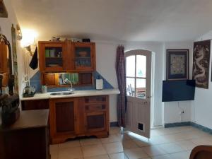 a kitchen with wooden cabinets and a sink and a window at Bica da Salema Beach House in Salema