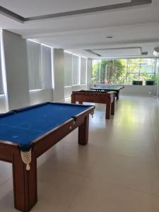 three pool tables in a large room with white floors at Flat Palladium São Vicente in São Vicente