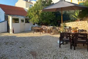 a patio with a table and an umbrella at Bica da Salema Beach House in Salema +5 photos