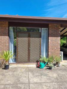 a house with a large glass door with potted plants at Retreat in Stirling in Stirling